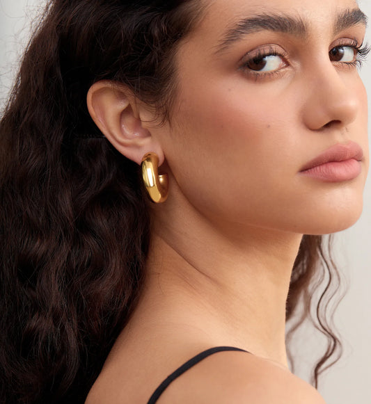 Close-up shot of Waterproof stainless steel Bold Gold Chunky Hoops on model‘s side face by Liora Senar