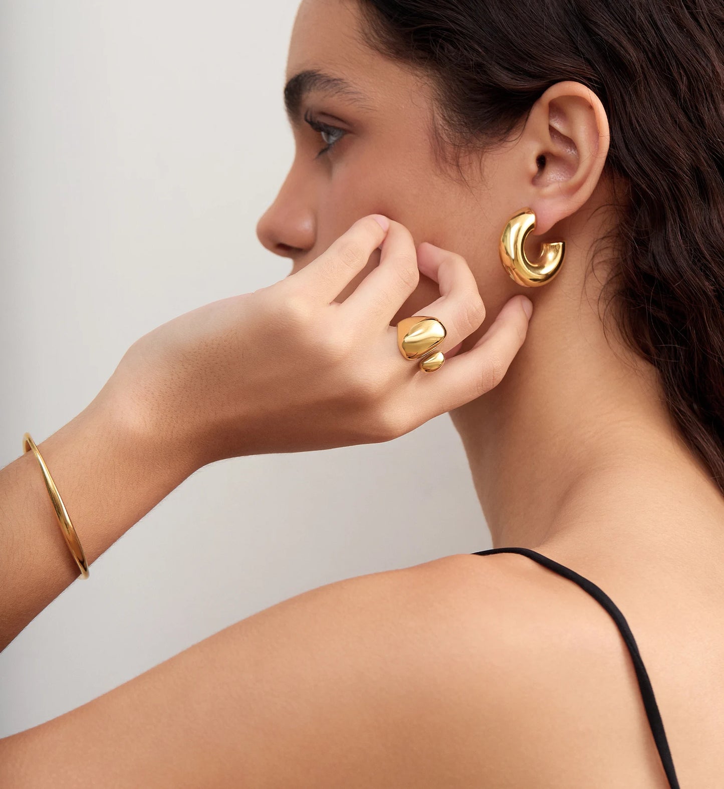 Side image of model wearing waterproof stainless steel Bold Gold Chunky Hoops,Ring and Bracelet by Liora Senar
