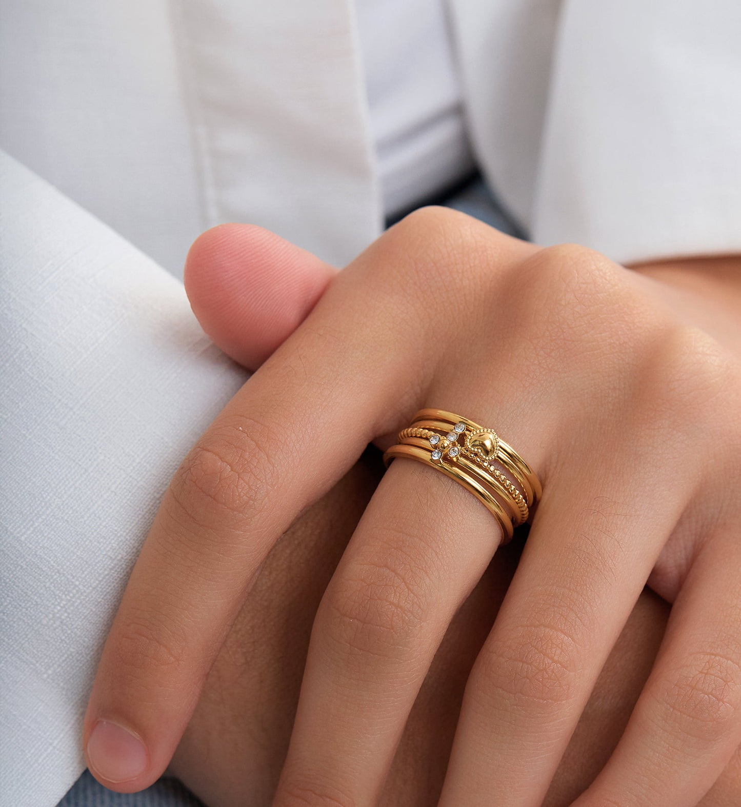 Gold color warranty cross-heart trio ring set stacking worn by a model by Liora Senar