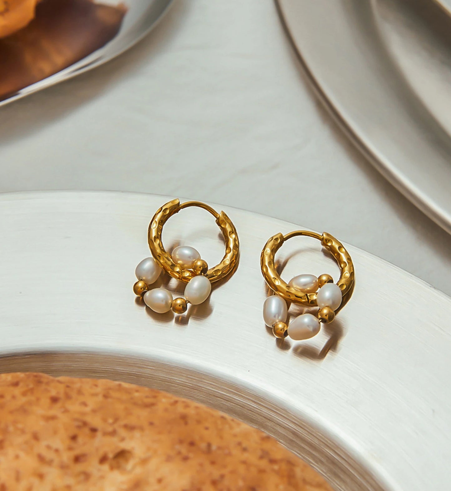 Lifestyle shot of minimalist gold Duo-loop pearl hoops by Liora Senar