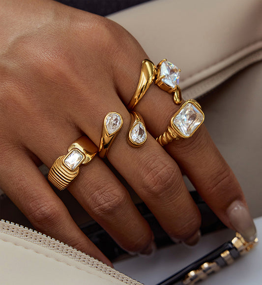 Model wearing gold stainless steel Ethereal Drop Ring with other cubic zirconia rings by Liora Senar