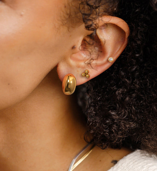Model wearing minimalist gold stainless steel stud set
