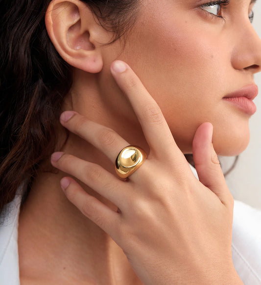 Model wearing gold waterproof stainless steel Orb Lust Ring by Liora Senar