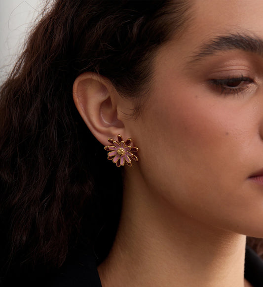 Rosy daisy earrings on a model's side face by Liora Senar
