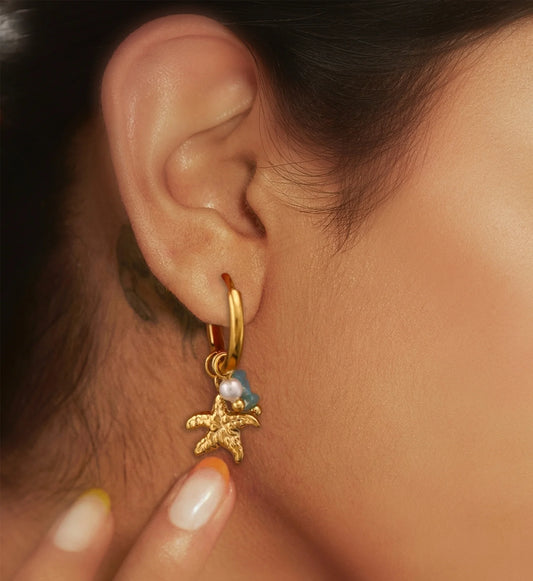 Model wearring hypoallergenic seaside charms huggie earrings by Liora Senar