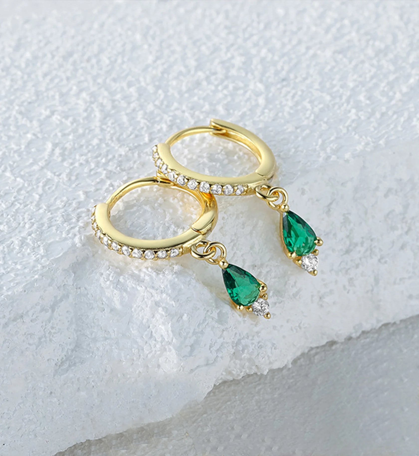 925 sterling silver emerald teardrop huggies  laying on white stone by Liora Senar