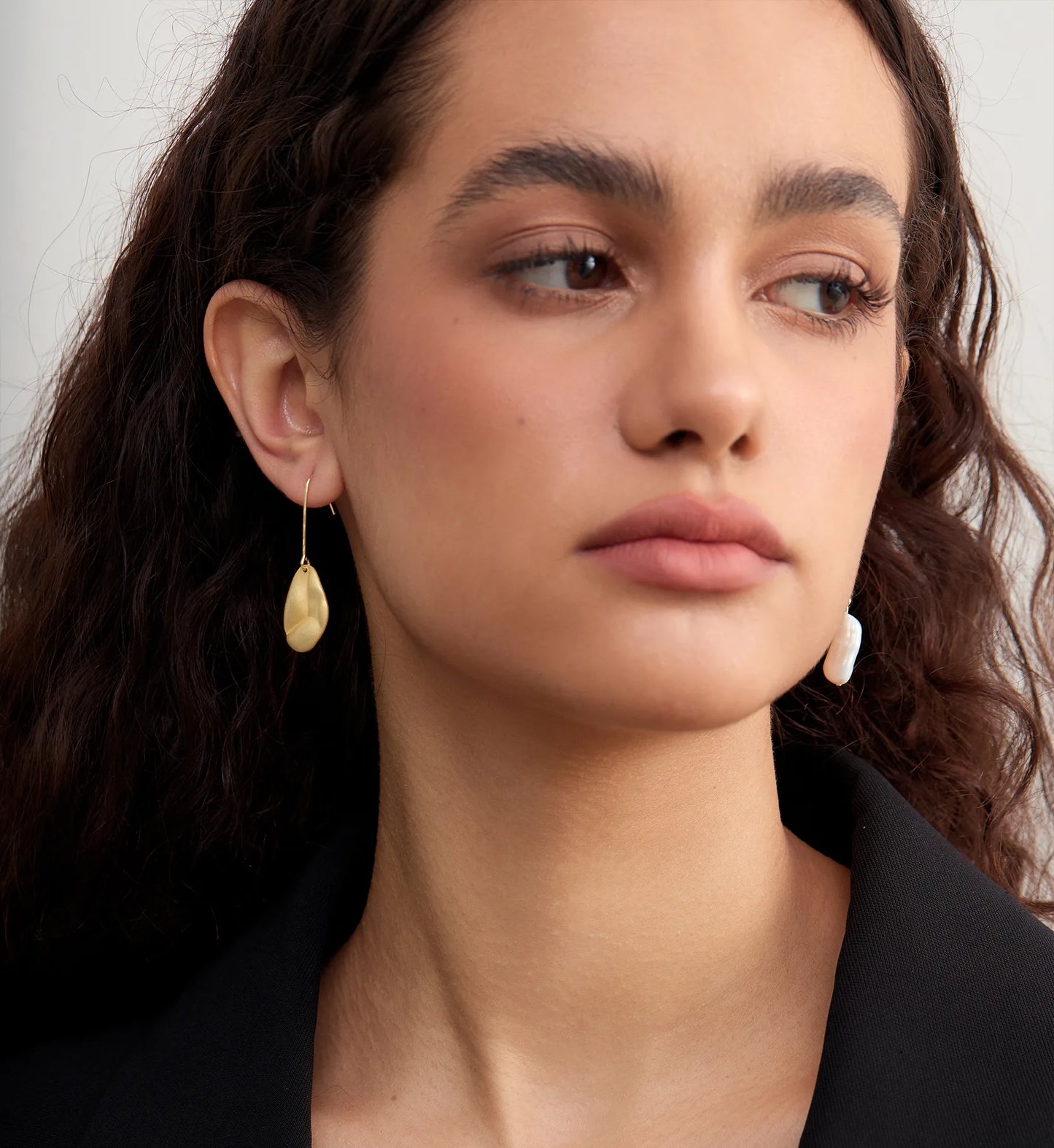 Model wearing hypoallergenic Baroque Pearl 925 Silver Asymmetric Drops by Liora Senar