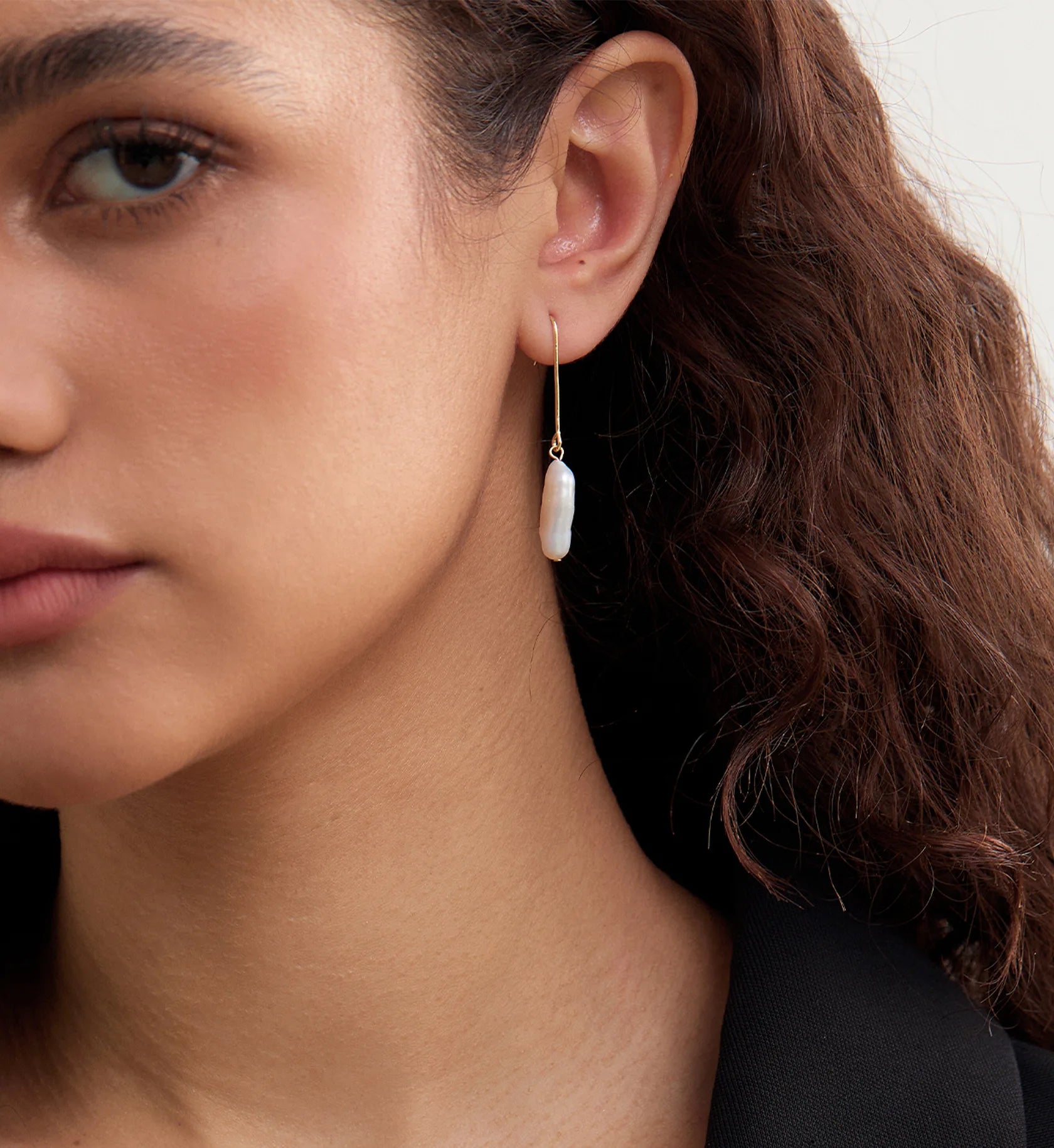 Model wearing a natural baroque pearl drop earring by Liora Senar