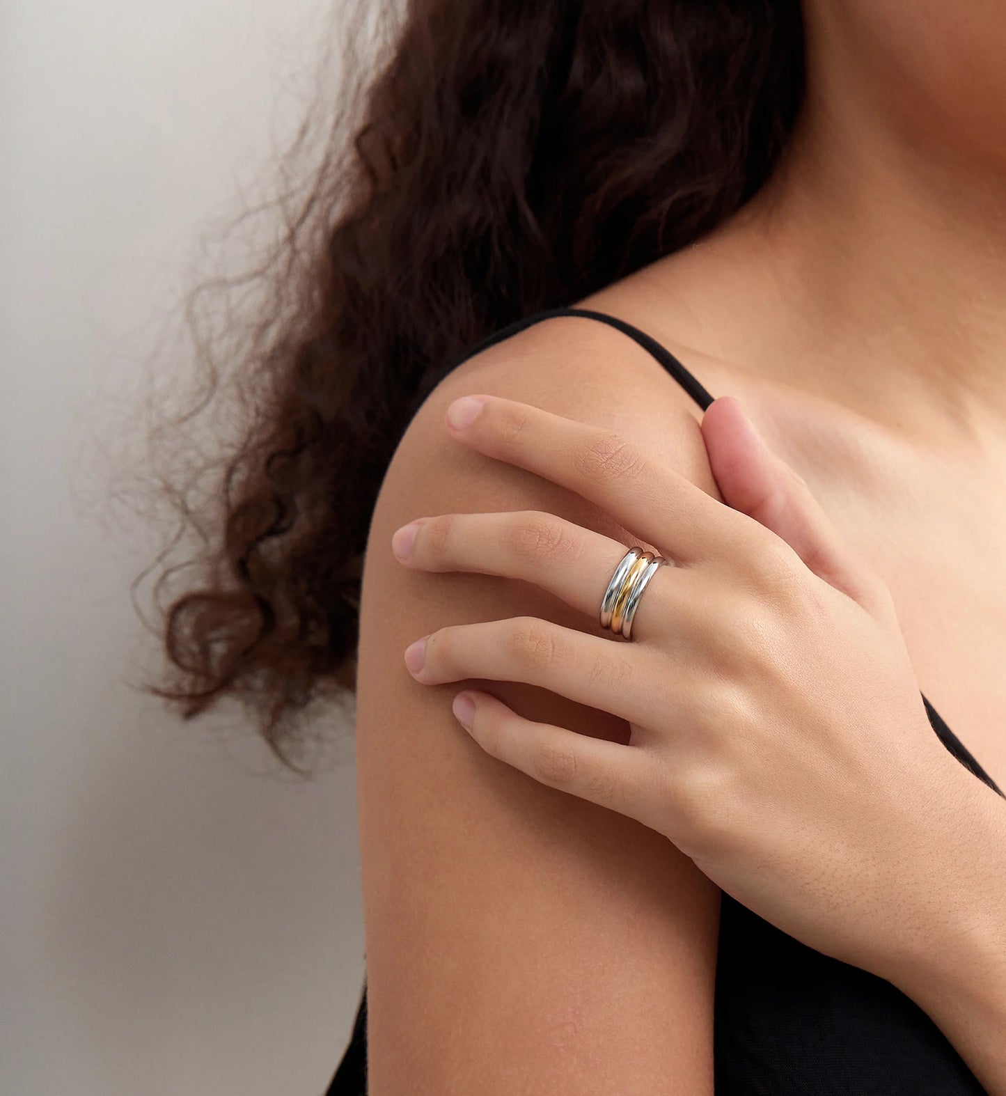 Model wearing color warranty 2-tone color Bi-Stream Band Ring in light gray background by Liora Senar