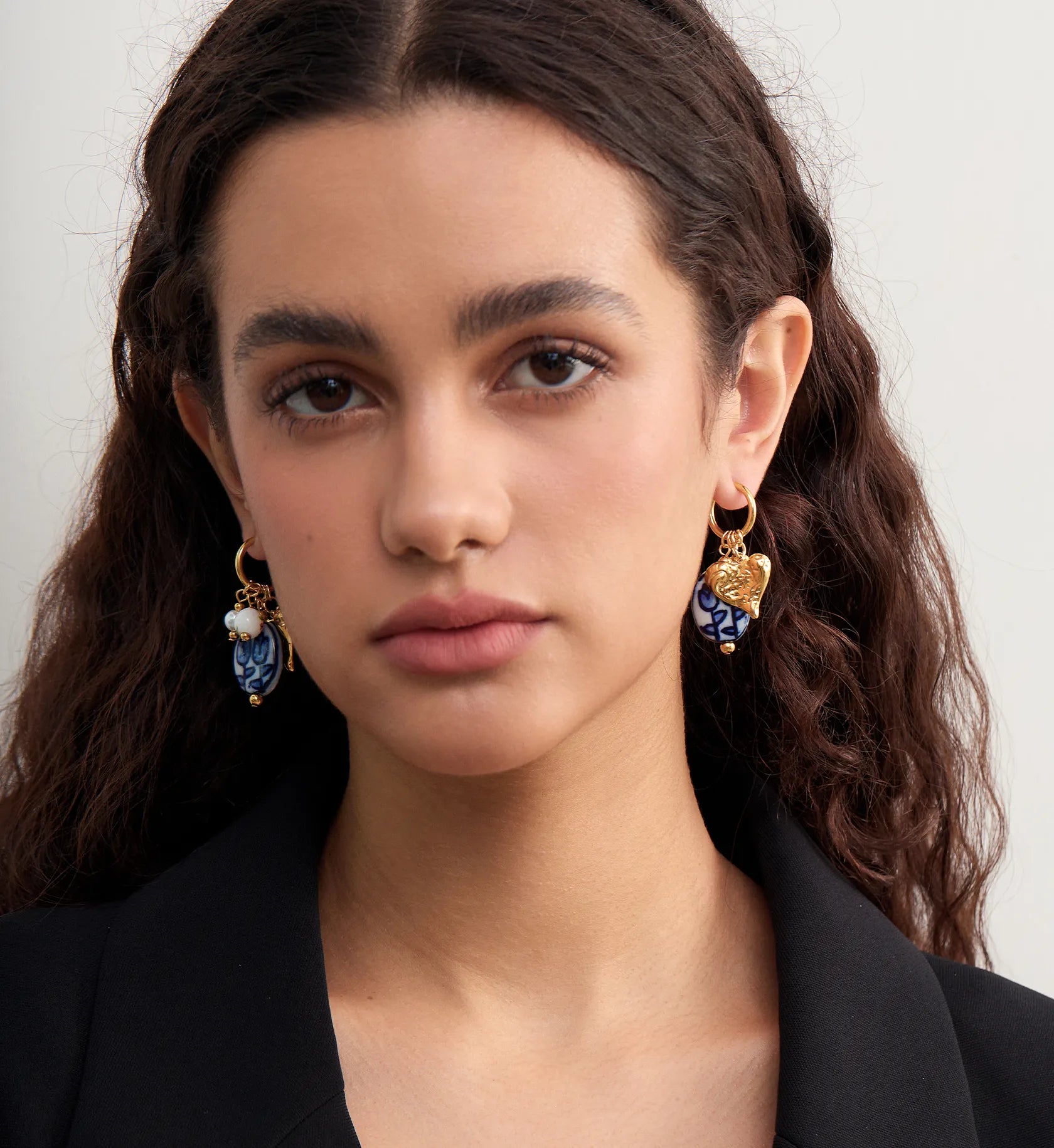 Model wearing waterproof Ceramic Heart Charm Hoops by Liora Senar
