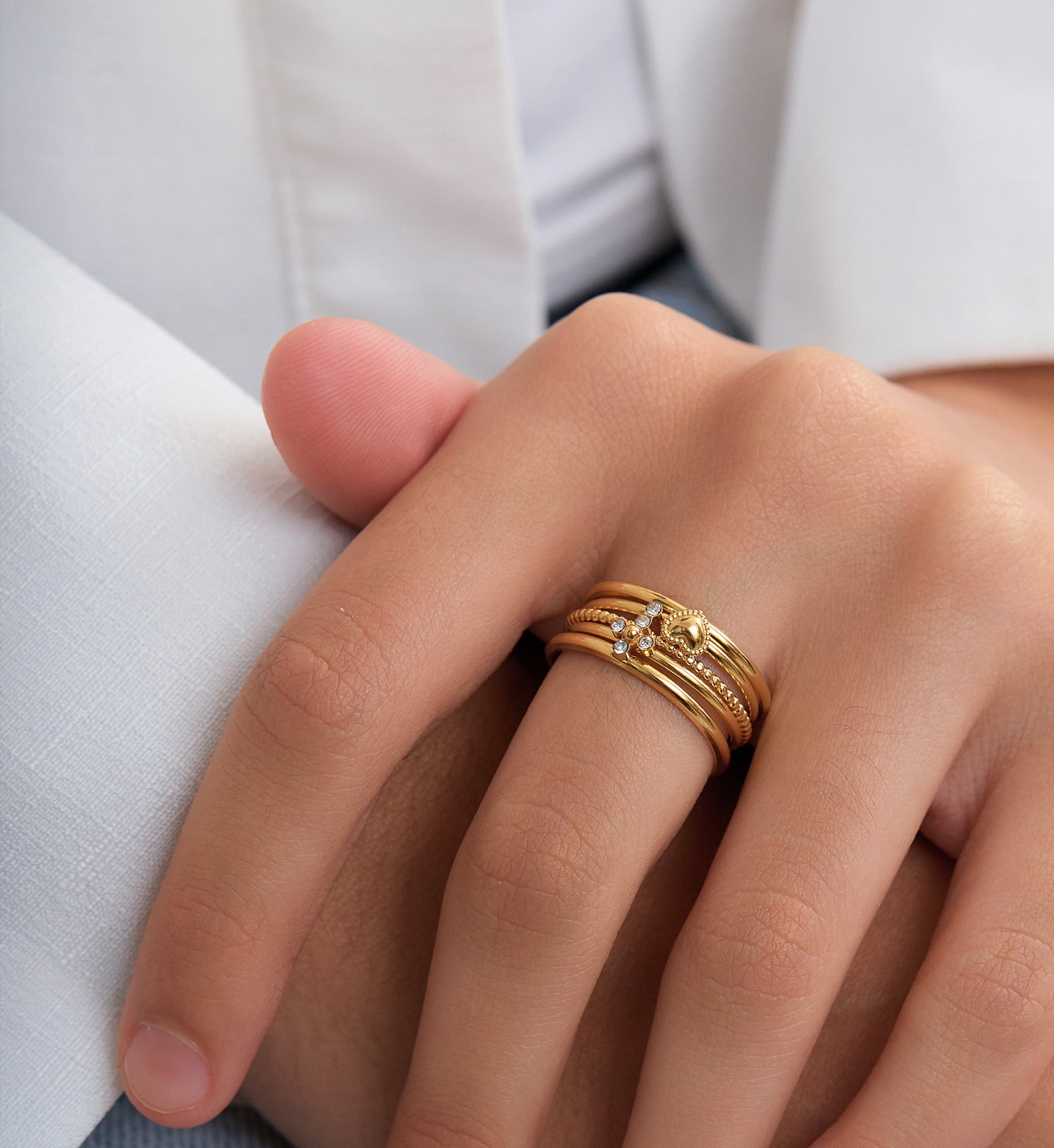 Gold color warranty cross-heart trio ring set stacking worn by a model by Liora Senar