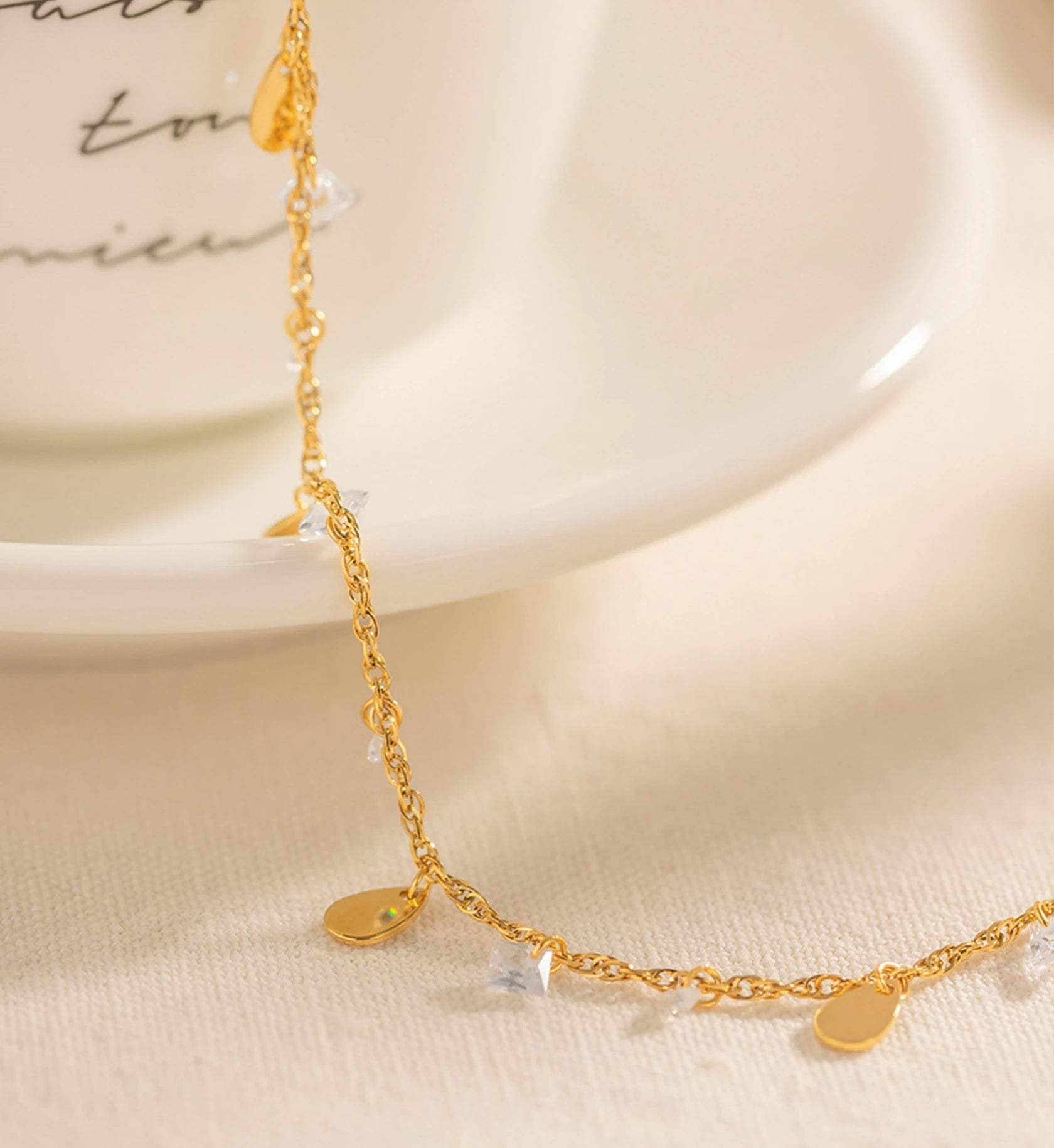 Close-up shot of detail of gold stainless steel Crystal Dew Anklet by Liora Senar