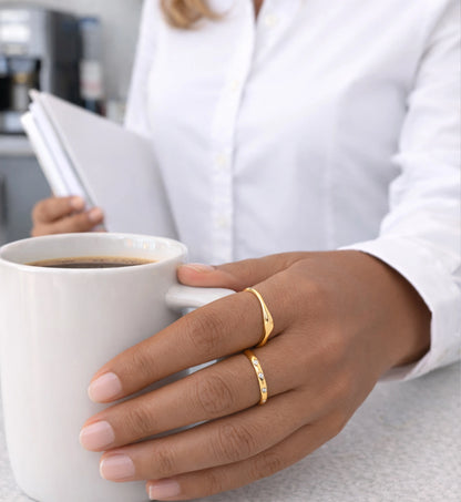 An office lady is lifting a coffee wiht the hand wearing Liora Senar Flow Ring and Eterna Dot Ring 