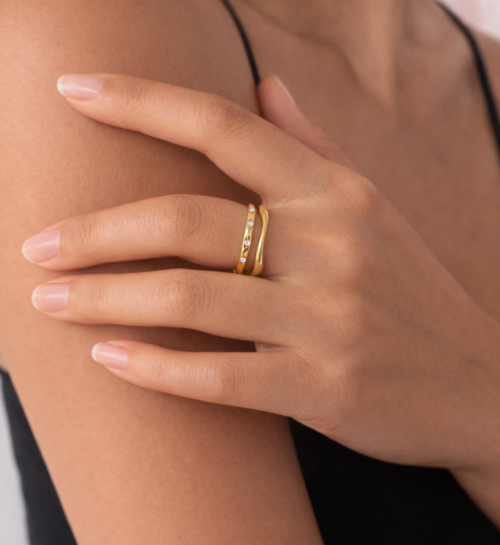 A model wearing the stackable rings Flow Ring and Eterna Dot Ring by Liora Senar