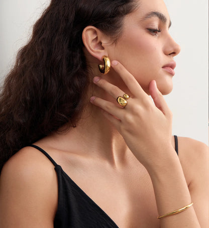 Model wearing Gold Geo-Hue Ring paired with gold hoops and braceletby Liora Senar