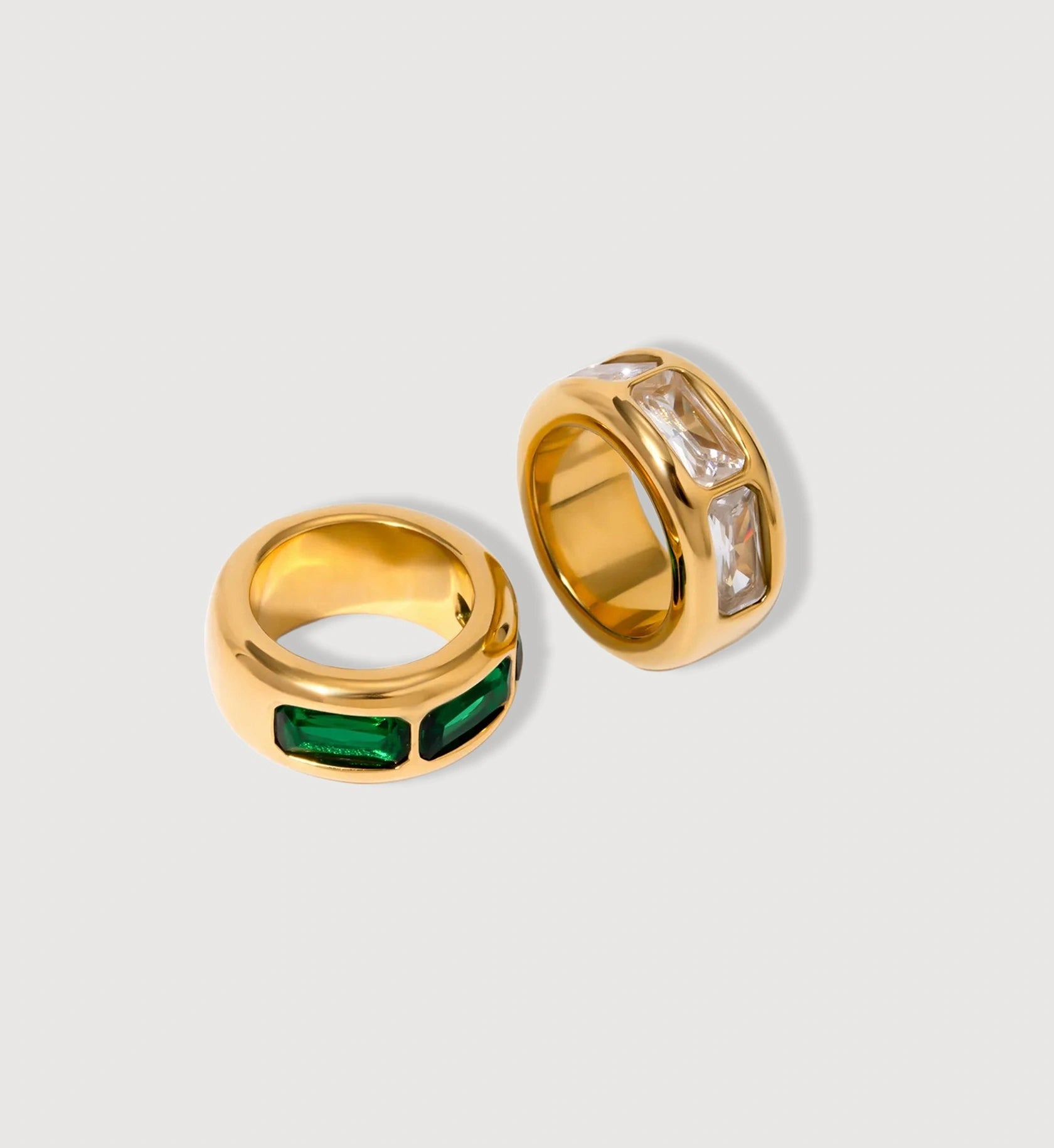 Gold waterproof Geo Lumina Ring with emerald and clear zirconia in light gray background by Liora Senar