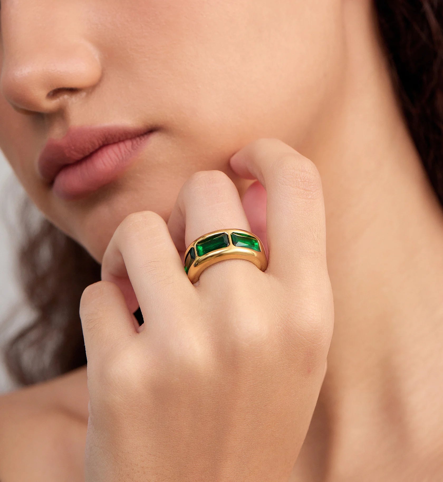 Model wearing waterproof Geo Lumina Ring with emerald zirconia by Liora Senar