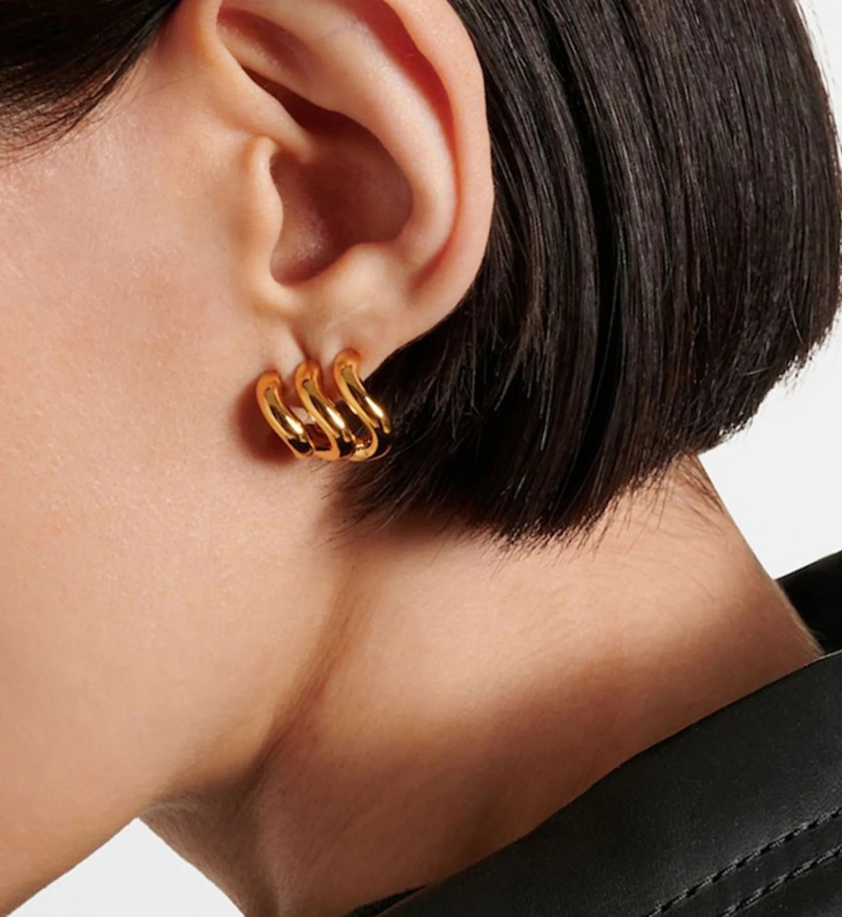 gold ripple curve earrings on a female model minimalist waterproof stainless steel jewelry