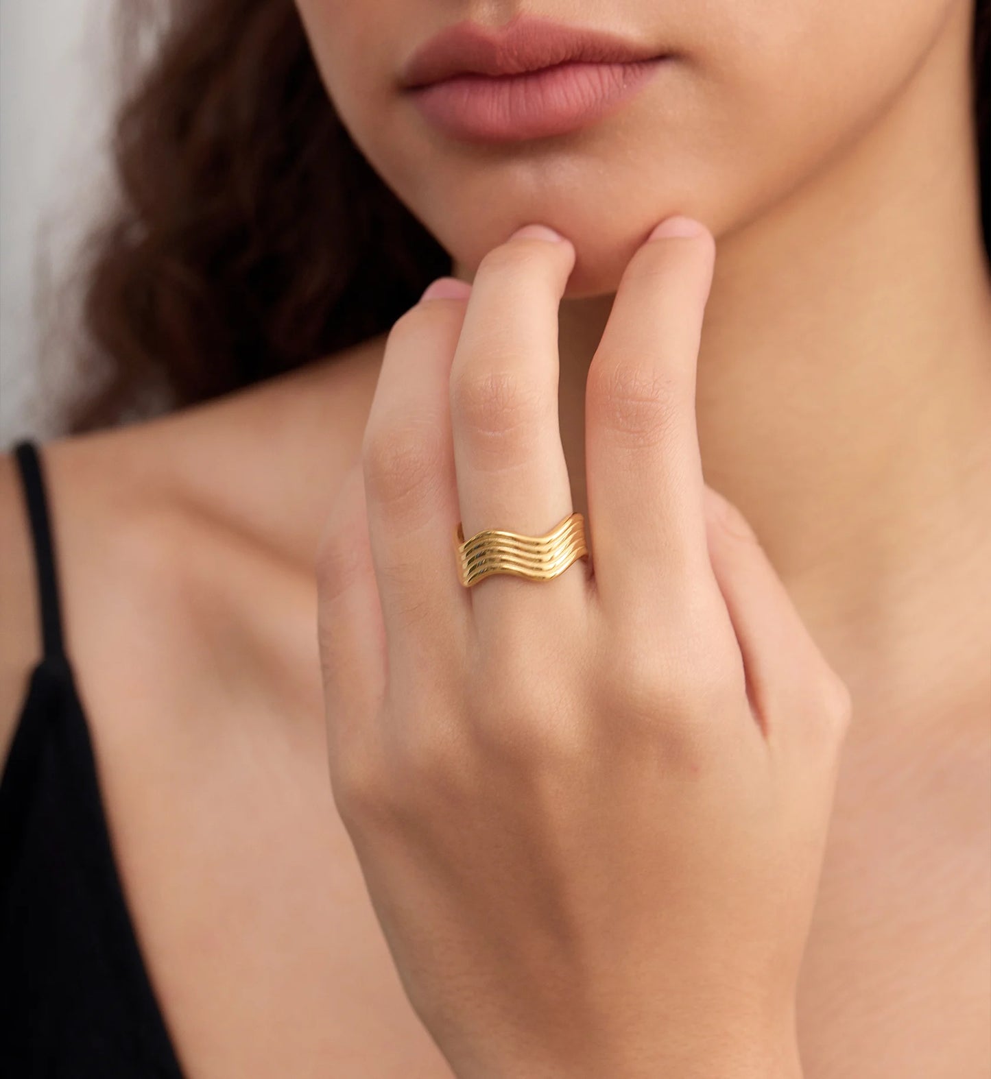 Model wearing minimalist gold wave ring by Liora Senar