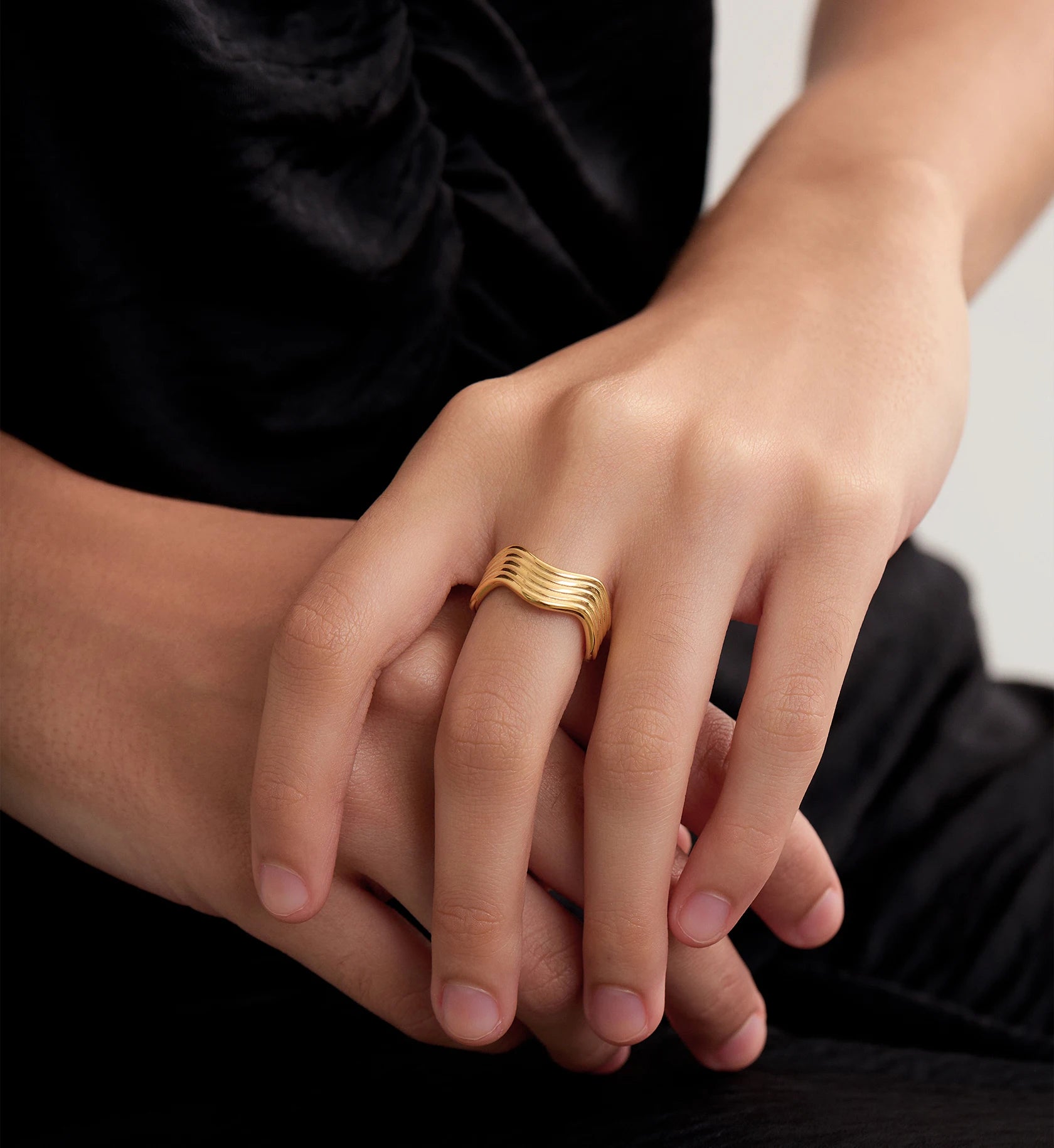 Model wearing minimalist slim gold wave ring by Liora Senar