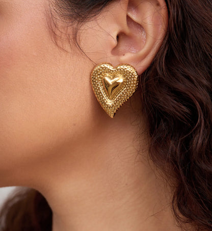 Close-up shot of hammered heart earrings on a model left side face by Liora Senar
