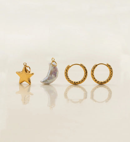 Natural pearl moon and gold stainless steel star charms and hoops stand separately in light beige background by Liora Senar