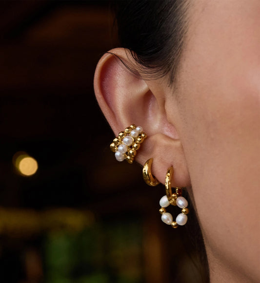 Model wearring 3 pieces of gold pearl hoop earrings and ear cuff byLiora Senar