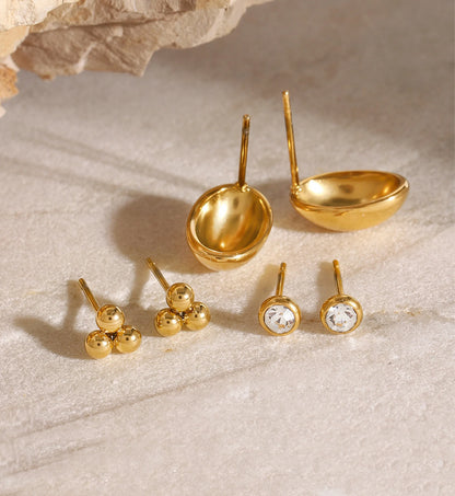 Close-up shot of minimalist gold color warranty stud set on marble by Liora Senar