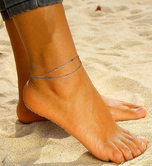 Model wearing 925 sterling silver hypoallergenic Ocean Layered Anklet on beach by Liora Senar