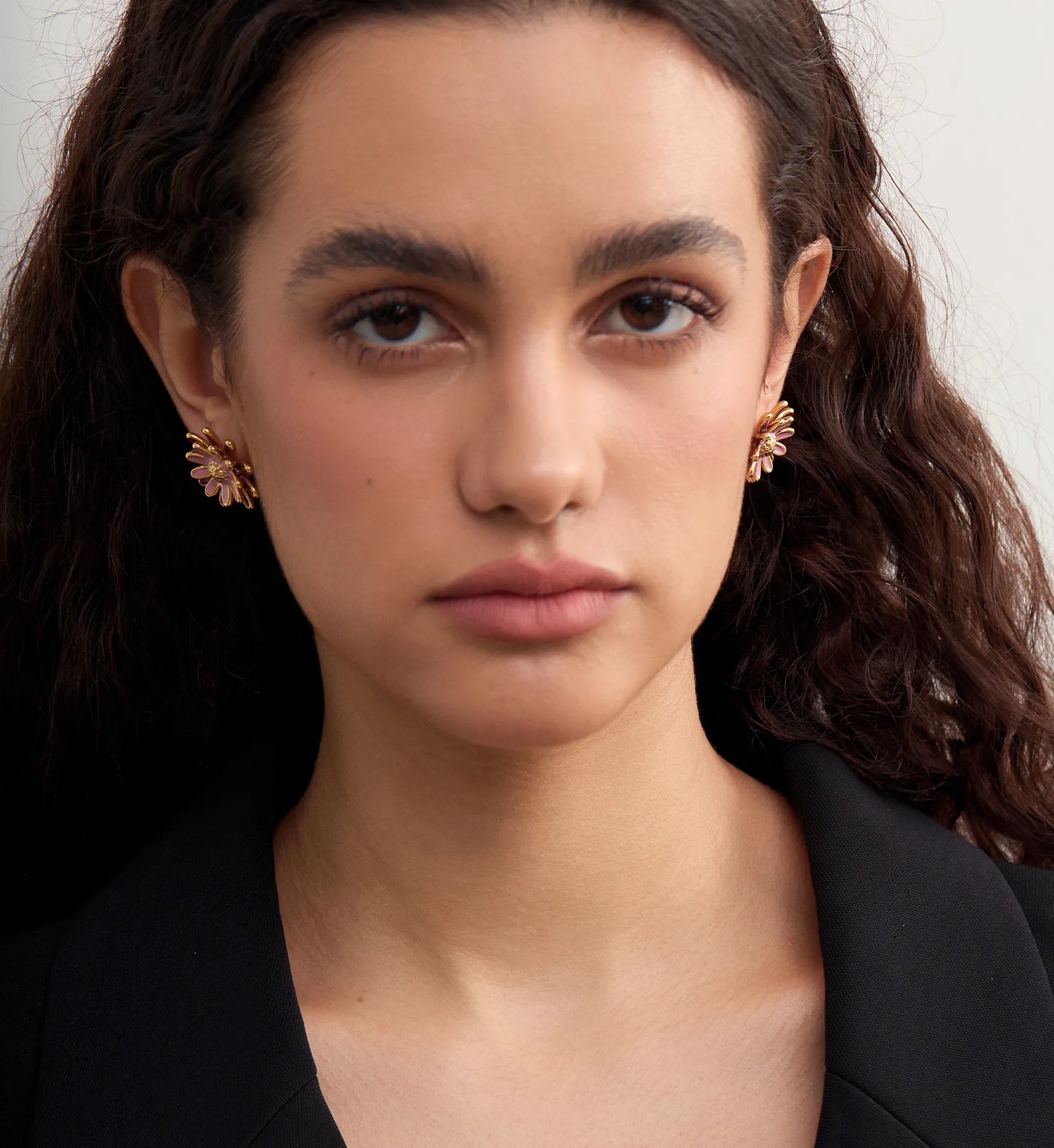 Minimalist rosy daisy earrings on a model by Liora Senar