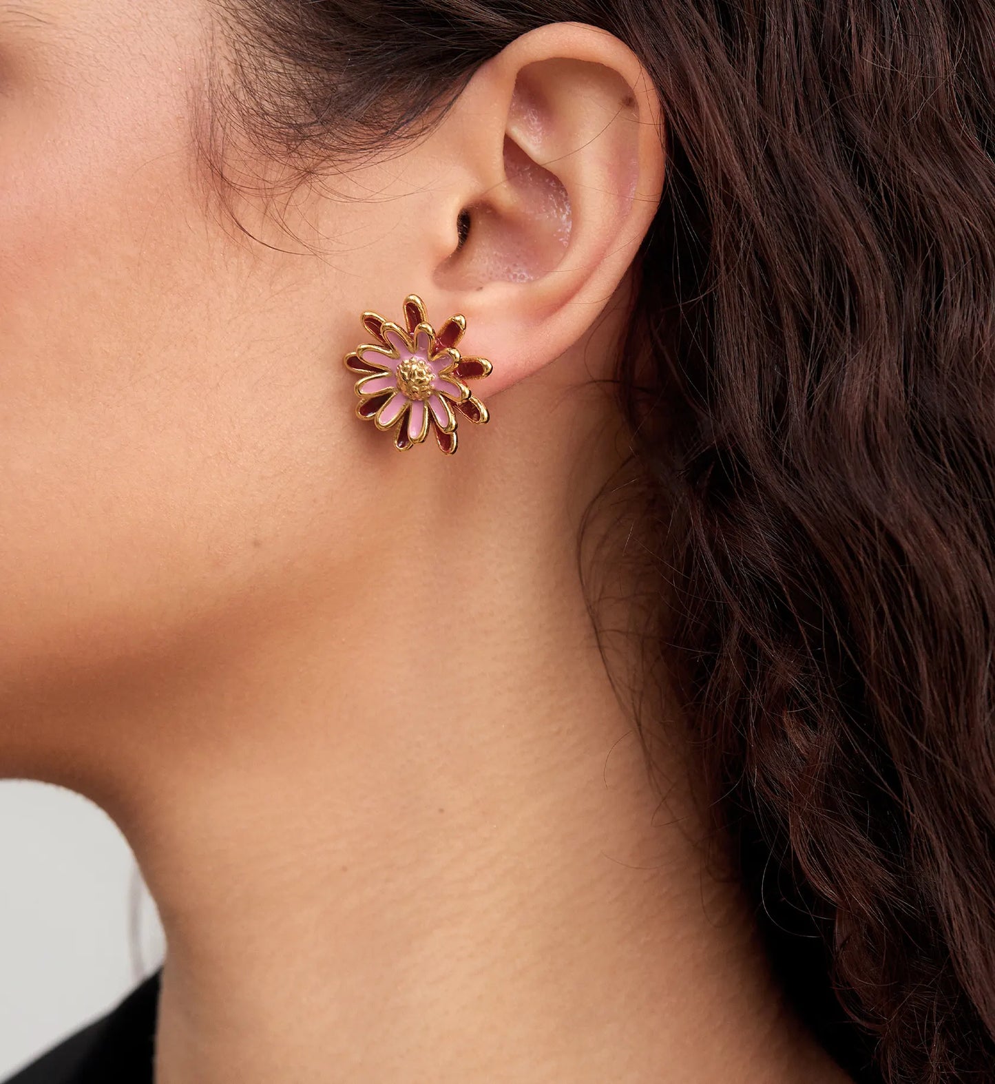 Close-up image of hypoallergenic  rosy daisy earrings on a model by Liora Senar
