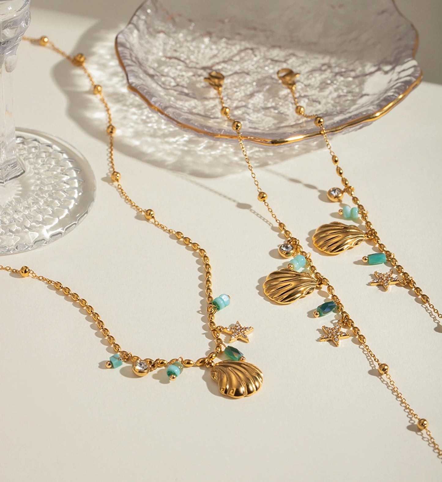 Gold seawater proof Seashell Star Necklace and Bracelet Bundle laying with glass by Liora Senar