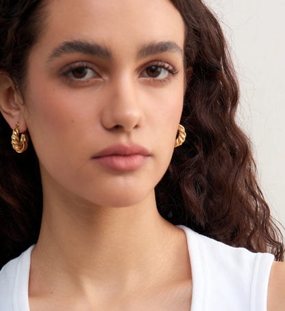 Model wearring minimalist waterproof Twisted Hoop Earrings by Liora Senar