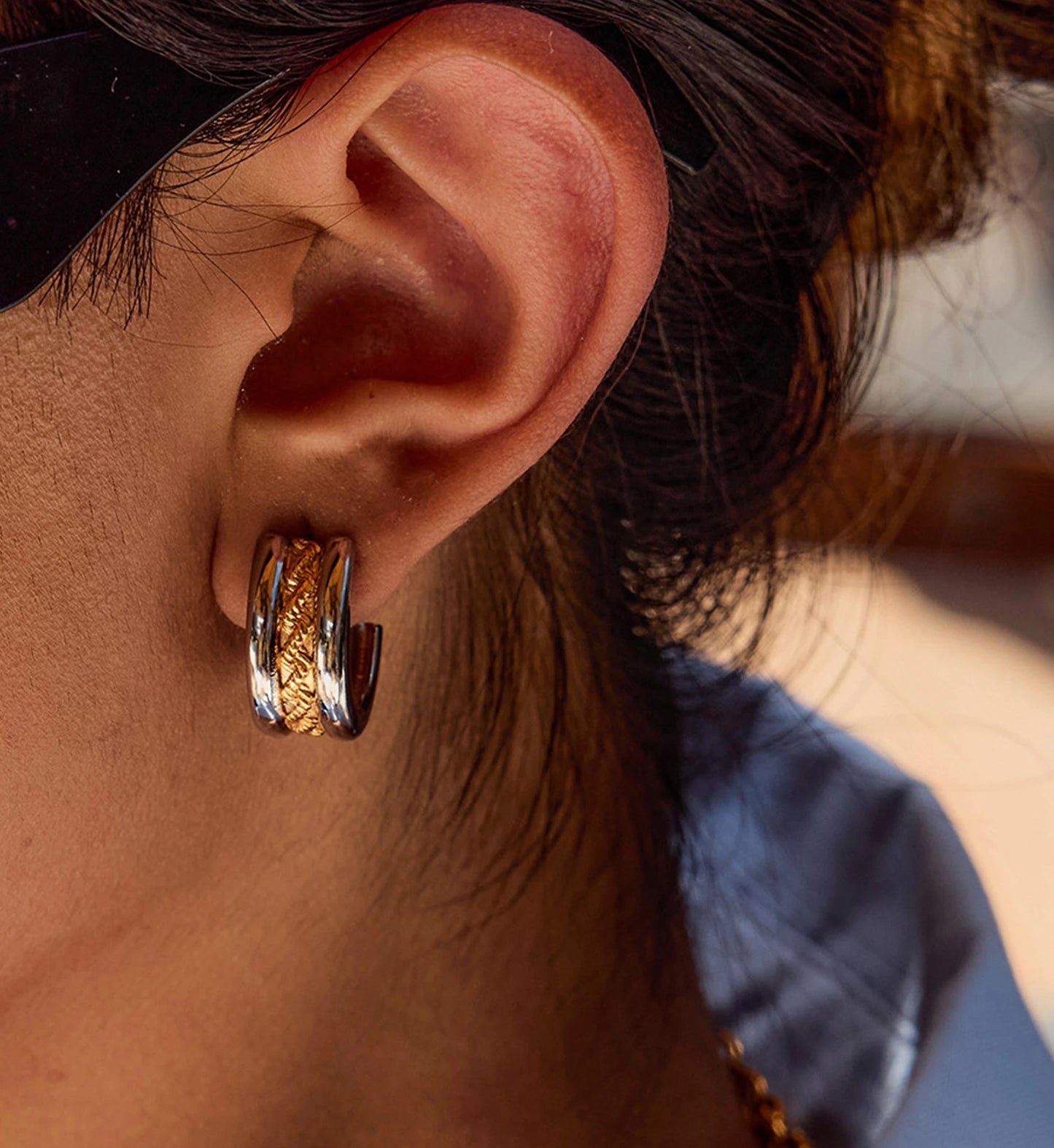 Model wearing hypoallergenic Two-Tone Twist Hoop Earrings by Liora Senar