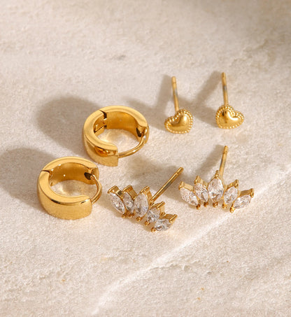 Stainless steel versatile heart earrings set laying on the marble by liora senar